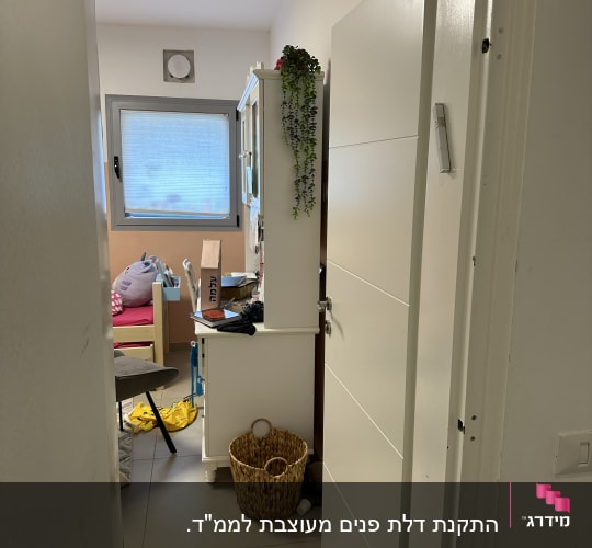 דלת לבנה פתוחה למחצה עם ידית כסופה